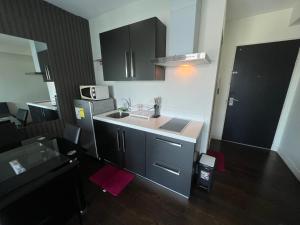 a small kitchen with a sink and a refrigerator at Acqua Private Residences - Livingstone Tower (Makati - Mandaluyong) in Manila +6 photos