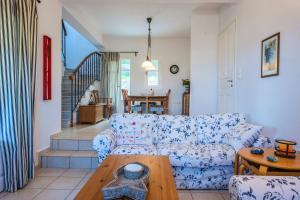 un soggiorno con divano e tavolo di Avrofilito Syros Houses a Ermoupoli