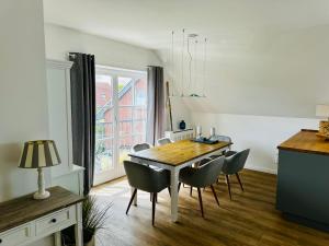 a kitchen and dining room with a table and chairs at Große deluxe Ferienwohnung mit Balkon, 2 SZ und nur 300m zum Strand in Kellenhusen