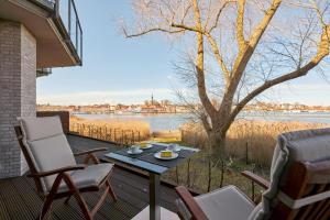a patio with a table and chairs and a view of the water at urlaubsART - Ostsee - Urlaub in Kappelns "Schleibrücke" in Kappeln