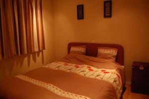 een klein bed in een slaapkamer met een sprei bij Chalet Europarcs Zuiderzee in Biddinghuizen