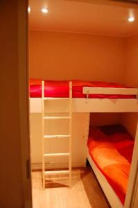 een slaapkamer met 2 stapelbedden met rode lakens bij Chalet Europarcs Zuiderzee in Biddinghuizen