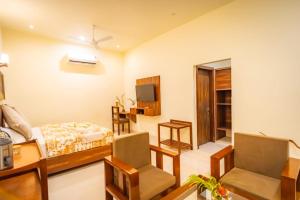 a bedroom with a bed and a desk and chair at Pristine Woods Resort in Dehradun