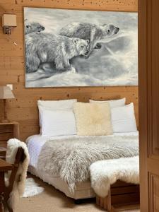 1 dormitorio con cama y una pintura de lobos en La Maison de Fleurat en Domeyrot