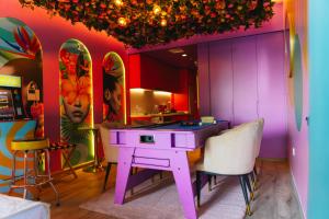 a pink kitchen with a pink table and chairs at Capsule Flora business bay view Burj Khalifa-pool table-game arcade-Projector-Playstation 5 in Dubai