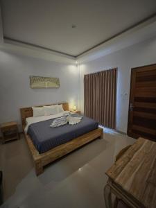 a bedroom with a bed with a blue comforter at The Lucky Canggu 2 in Canggu