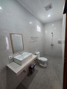 a bathroom with a sink and a toilet and a mirror at The Lucky Canggu 2 in Canggu