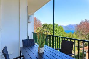 una mesa azul y sillas en un balcón con vistas en PepeNero, en Stresa