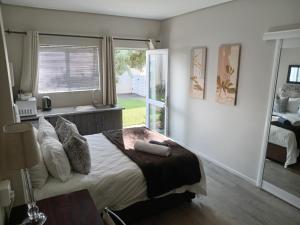 a bedroom with a large bed and a window at Urban Manor in Port Elizabeth