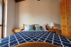 um quarto com uma cama azul e branca com almofadas em Valle Intelvi - Como Lake em San Fedele Intelvi