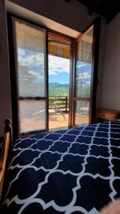 um quarto com uma cama azul e branca com vista em Valle Intelvi - Como Lake em San Fedele Intelvi