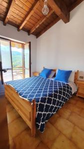um quarto com um edredão azul e branco numa cama em Valle Intelvi - Como Lake em San Fedele Intelvi