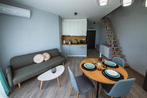 a living room with a couch and a table and chairs at AthmosphereVillaEma Apartments in Kranevo