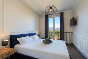 Un dormitorio con una cama grande con una ventana grande. en PepeNero, en Stresa