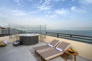 un balcón con bañera de hidromasaje y un spa en la azotea en Leonardo Plaza Hotel Tiberias en Tiberias