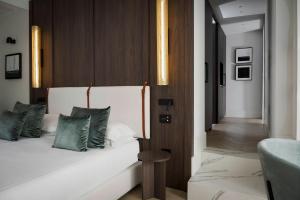 una camera da letto con un letto bianco con cuscini verdi di Hotel Maestrale a Riccione