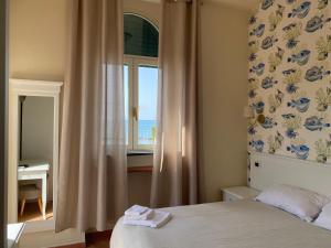 サンタ・マリネッラにあるVillino Gregoraci Relaisのベッドルーム1室(ベッド1台、海の景色を望む窓付)が備わります。
