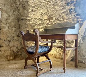 una silla de madera sentada frente a un escritorio en la Crémesine, en Baratier
