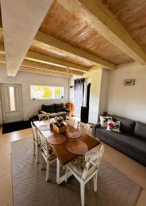 a living room with a table and chairs and a couch at Wanderlust Cottage Avrig in Avrig