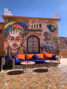a mural on the side of a building with a couch at Kasbah Isfoula and Spa in Aït Benhaddou