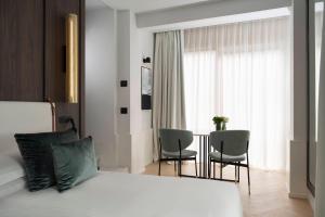 a bedroom with a bed and two chairs and a window at Hotel Maestrale in Riccione