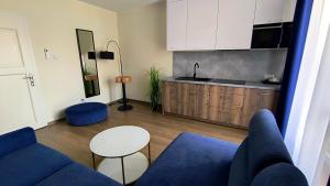 salon z niebieską kanapą i kuchnią w obiekcie La Mer Pokoje i Apartamenty we Władysławowie +35 zdjęć