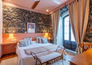 a bedroom with a bed and a stone wall at Mar Del Sueve in Colunga