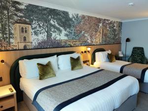 ein Hotelzimmer mit 2 Betten und einem Gemälde an der Wand in der Unterkunft Menlo Park Hotel in Galway