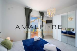 コンカ・デイ・マリーニにあるCasa Angelinaのベッドルーム1室(青いベッド1台、ガラスドア付)
