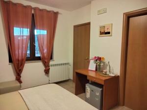 a bedroom with a bed and a desk and a window at Casale di Valle Fredda in Itri