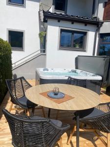 een patio met een tafel en stoelen en een hot tub bij Apartment in der Au in Langkampfen