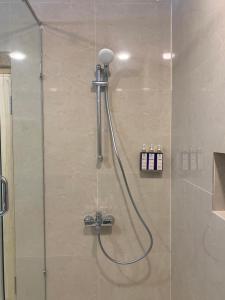 a shower with a shower head in a bathroom at Guzel Hotel in Shigar