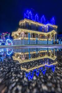 a house with lights in the water at night at Grand Gables Inn in Palatka
