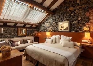 - une chambre avec un grand lit et un mur en pierre dans l'établissement Mar Del Sueve, à Colunga