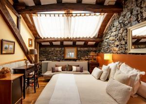a bedroom with a large bed and a stone wall at Mar Del Sueve in Colunga