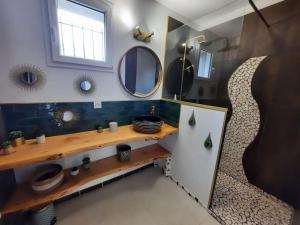 a bathroom with a counter and mirrors on the wall at Maison avec jardin près de Luchon in Cazaux-Layrisse