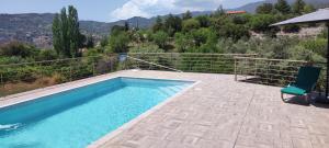 a swimming pool with a chair and an umbrella at Roses Villa in Trimiklini