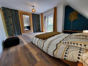 a bedroom with a large bed and a large window at Maison avec jardin près de Luchon in Cazaux-Layrisse