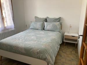 Schlafzimmer mit einem Bett und einem Beistelltisch in der Unterkunft Maison dans un village viticole in Boyeux-Saint-Jérôme