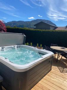 a hot tub on a deck with a table and a patio at Apartment in der Au in Langkampfen