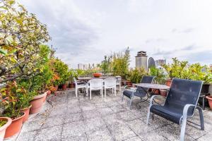 um pátio com cadeiras, mesas e vasos de plantas em Appartement avec terrasse a 5 min de Paris em Les Lilas