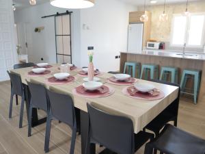 a dining room table with chairs and bowls and plates at Nina´s Paradise in L'Ampolla