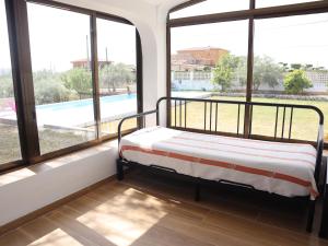 a bed in a room with large windows at Nina´s Paradise in L'Ampolla