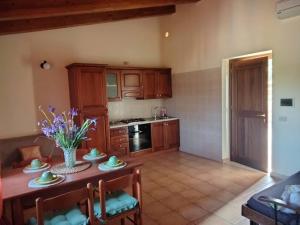 eine Küche mit einem Tisch und Stühlen sowie eine Küche mit einem Herd in der Unterkunft Casale di Valle Fredda in Itri