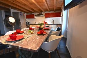 una cocina con una mesa larga con platos rojos. en DUPLEX 5 chambres Cannes, en Cannes