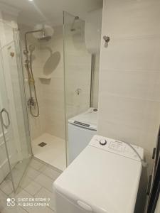 ein weißes Bad mit einer Dusche und einem WC in der Unterkunft Las Canteras, your beach home in Las Palmas de Gran Canaria
