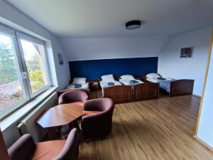 a room with two beds and a table and chairs at Pokoje u Gruszki in Swarzewo