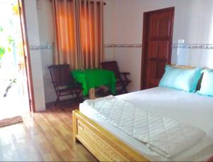 um quarto com uma cama e uma mesa com cadeiras em NHÀ NGHỈ LONG VIÊN em Hàm Tân