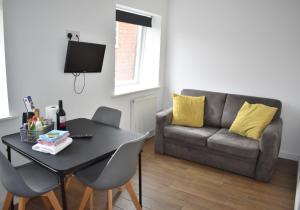 a living room with a table and a couch at Chichester Retreat - Quiet City Centre Apartment in Chichester