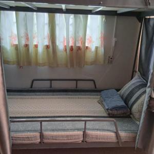 een bed in een kleine kamer met een gordijn bij Dorm Can Tho in Can Tho